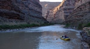 Rafter floating through canyons on San Juan River